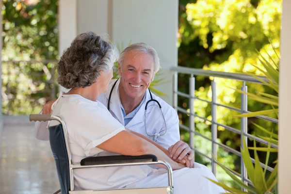 Doctor with his patient in her wheelchair — Stock Photo, Image