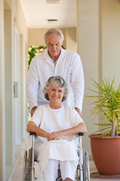 Läkare med sin patient i hennes rullstol — Stockfoto
