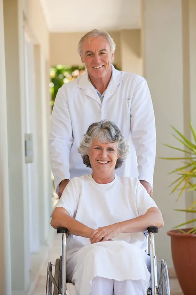Arzt mit seiner Patientin im Rollstuhl — Stockfoto