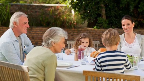 Rodina jíst v zahradě — Stock fotografie