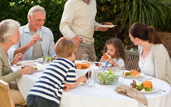 Adorable familia comiendo en el jardín —  Fotos de Stock