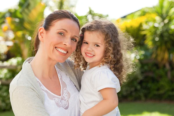 Mother with her daughter looking at the camera in the garden — Stock Photo, Image