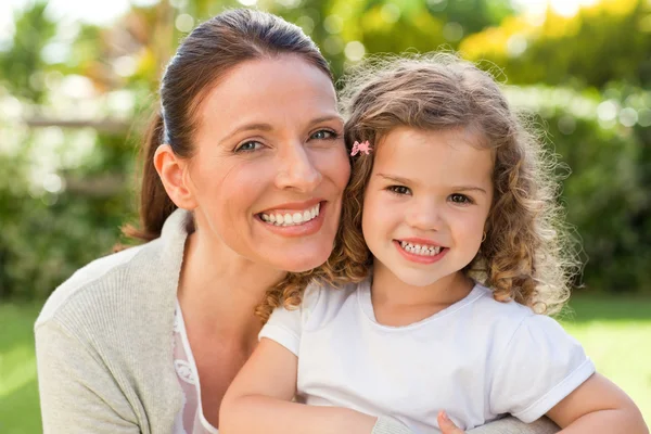 Mother with her daughter looking at the camera in the garden — Stock Photo, Image