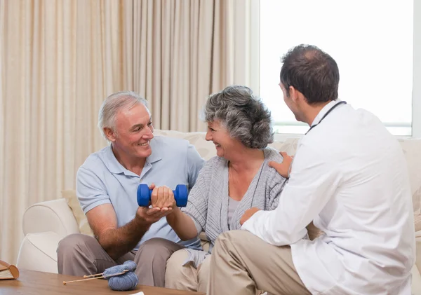 Handsome doctor helping his patient to do exercises — Stock Photo, Image