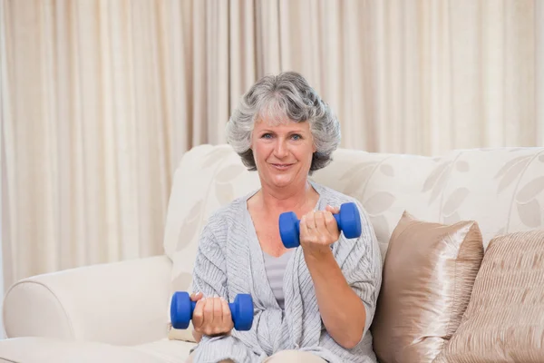 Женщина делает упражнения на диване — стоковое фото