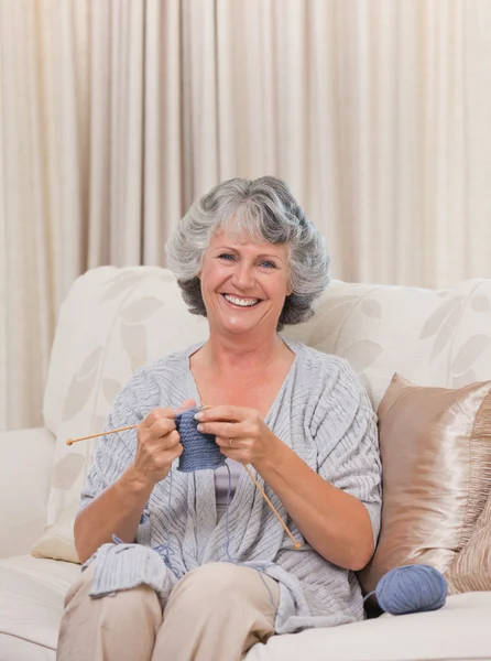 Retired woman knitting at home — Stock Photo, Image