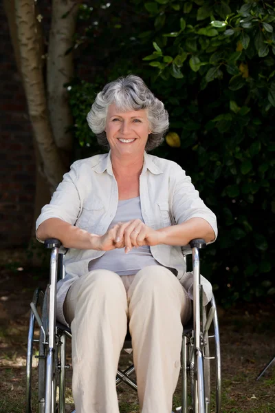 Mulher sorridente em sua cadeira de rodas — Fotografia de Stock