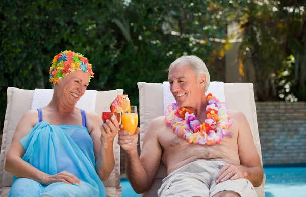 Счастливая старшая пара пьет коктейли и тосты друг за друга — стоковое фото