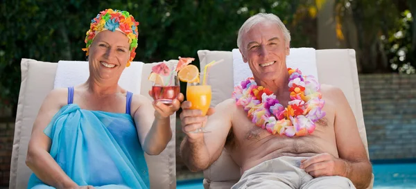 Ώριμο ζευγάρι πίνοντας ένα κοκτέιλ δίπλα στην πισίνα — Φωτογραφία Αρχείου
