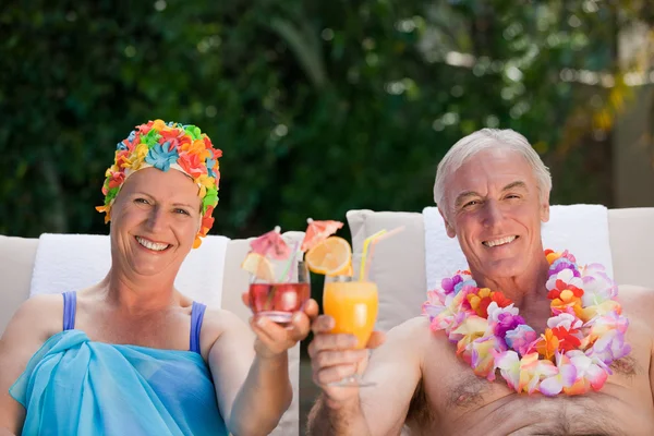 Äldre par dricka en cocktail vid poolen — Stockfoto
