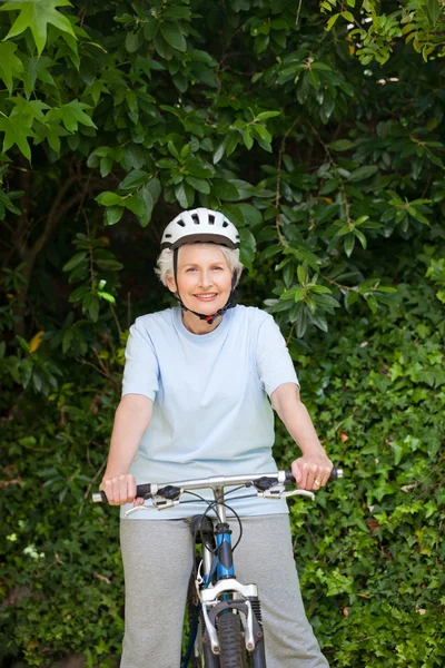 成熟的女人骑山地自行车外 — 图库照片