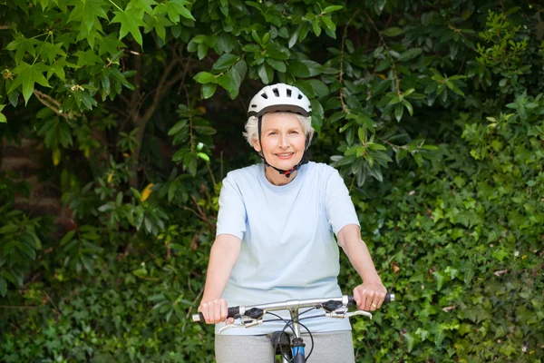 Olgun kadın dağ bisikleti dışarıda — Stok fotoğraf