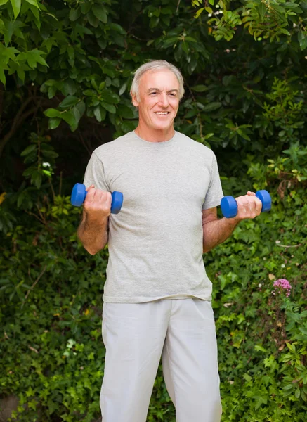 Hombre mayor haciendo sus ejercicios en el jardín — Foto de Stock