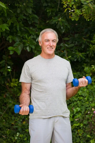 Hombre mayor haciendo sus ejercicios en el jardín —  Fotos de Stock