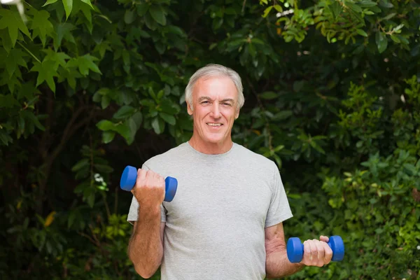 Hombre mayor haciendo sus ejercicios en el jardín — Foto de Stock