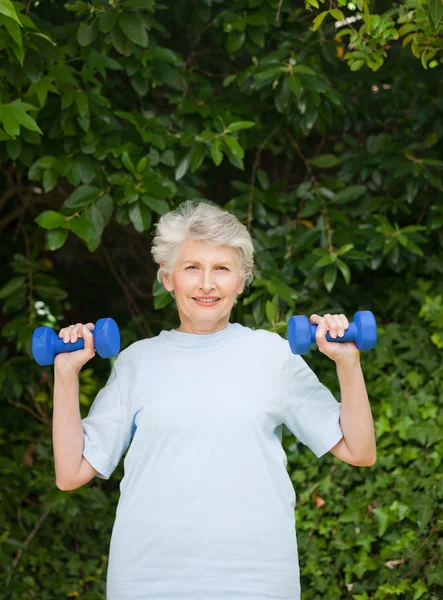 Зрелая женщина делает упражнения в саду — стоковое фото