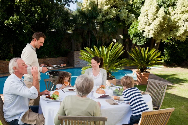 Rodina jíst v zahradě — Stock fotografie