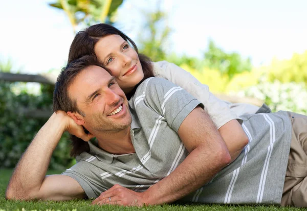 Couple lying down in the garden — Stock Photo, Image