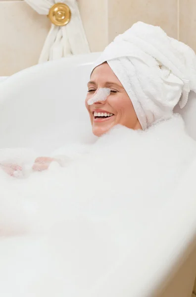 Linda mulher tomando um banho com uma toalha na cabeça — Fotografia de Stock