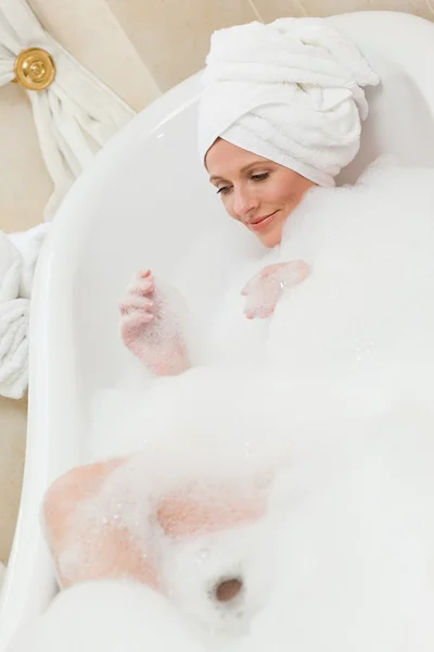 Krásná žena ve vaně s ručníkem na hlavě — Stock fotografie