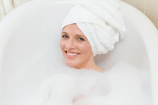 Härlig kvinna tar ett bad med en handduk på huvudet — Stockfoto