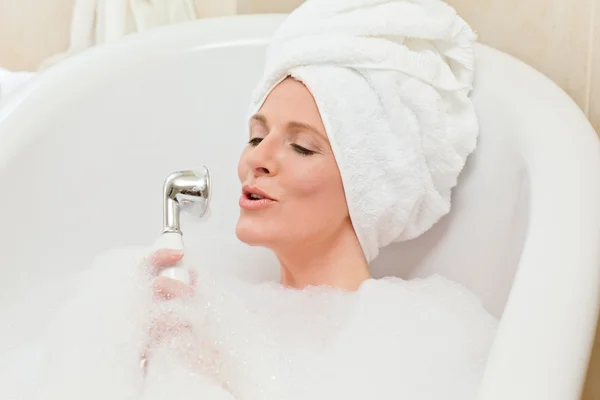 Charmig kvinna tar ett bad med en handduk på huvudet — Stockfoto