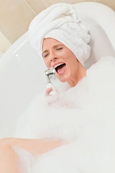 魅力的な女性が彼女の頭の上にタオルで浴室を取っています。 — ストック写真