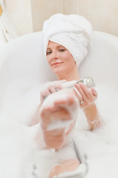 Mulher sorridente tomando um banho com uma toalha na cabeça — Fotografia de Stock
