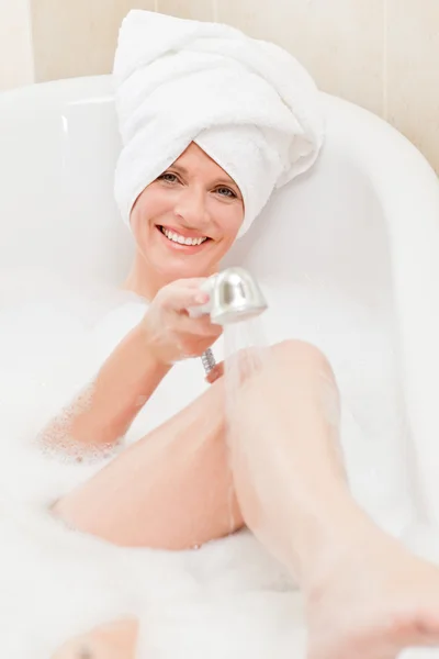 Femme souriante prenant un bain avec une serviette sur la tête — Photo