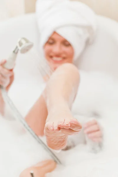 Femme souriante prenant un bain avec une serviette sur la tête — Photo