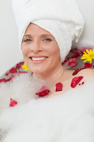 Розслаблена жінка приймає розслаблюючу ванну з рушником на голові — стокове фото