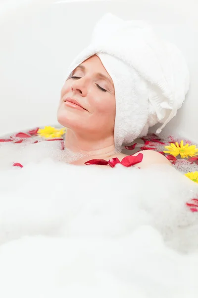 Uvolněná žena užívat relaxační koupel s ručníkem na hlavě — Stock fotografie