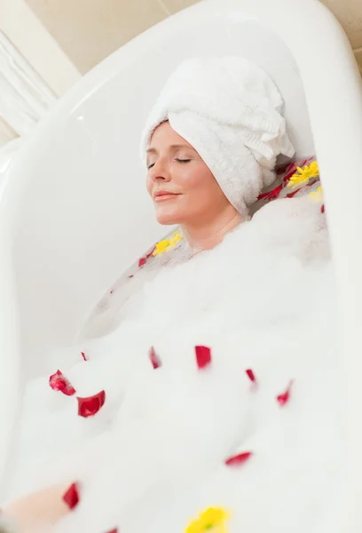 Mooie vrouw nemen een ontspannend bad met een handdoek op haar hoofd — Stockfoto