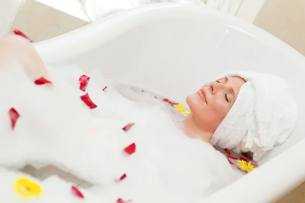 Vacker kvinna med ett avkopplande bad med en handduk på huvudet — Stockfoto