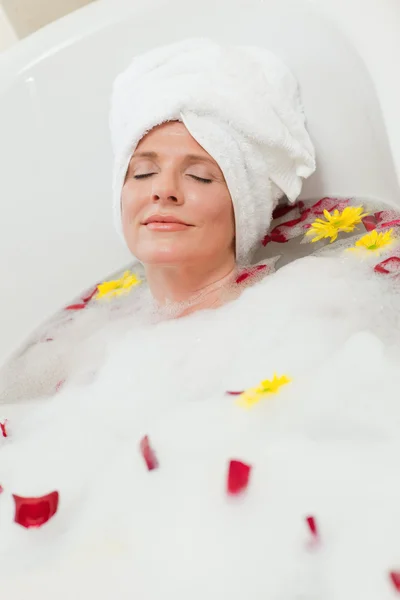 Pretty woman taking a relaxing bath with a towel on her head — Stock Photo, Image