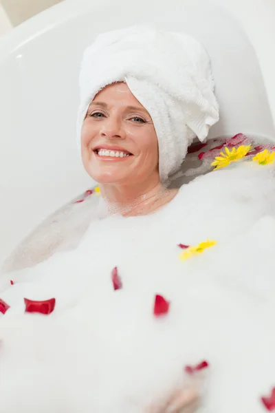 Mulher bonita tomando um banho relaxante com uma toalha na cabeça — Fotografia de Stock