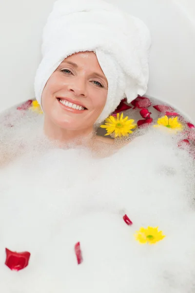 Mulher bonita tomando um banho relaxante com uma toalha na cabeça — Fotografia de Stock