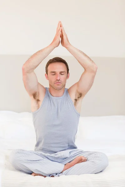 Hombre practicando yoga en su cama — Foto de Stock