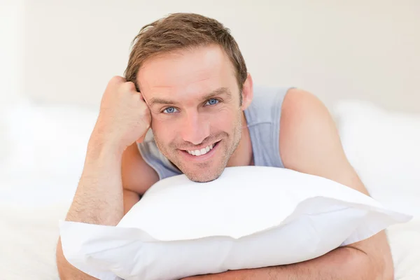 Man lying down on his bed — Stock Photo, Image