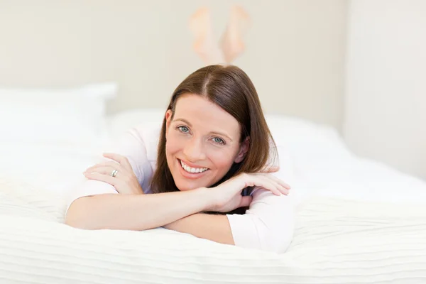 Красивая женщина лежит на кровати — стоковое фото