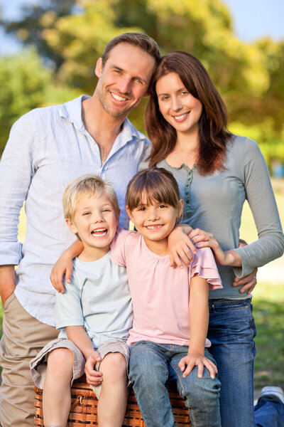 Leende familj picknick i parken — Stockfoto