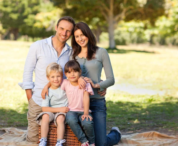 Família sorrindo piquenique no parque — Fotografia de Stock
