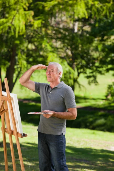 Uomo anziano pittura in giardino — Foto Stock