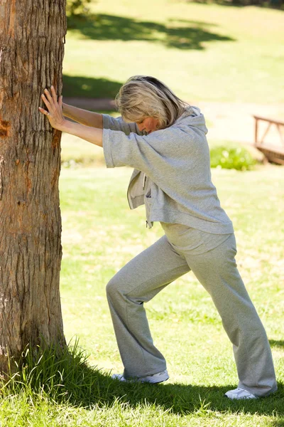 Зрелая женщина в парке делает стриптиз. — стоковое фото