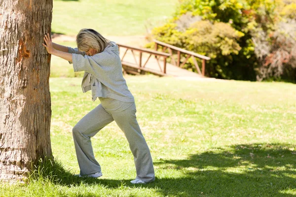 Mature woman doing her streches in the park — Stock Photo, Image
