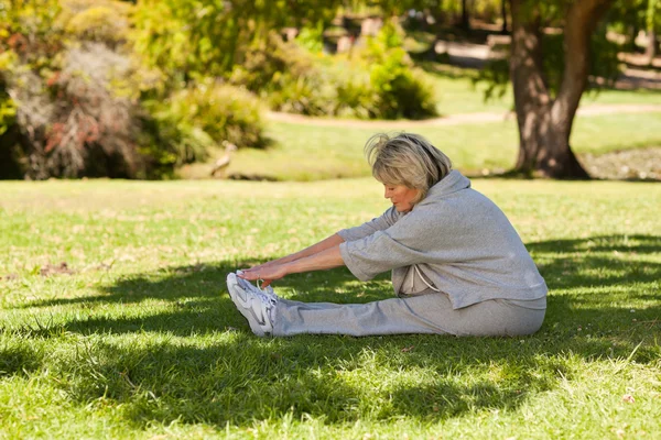 Зрелая женщина в парке делает стриптиз. — стоковое фото