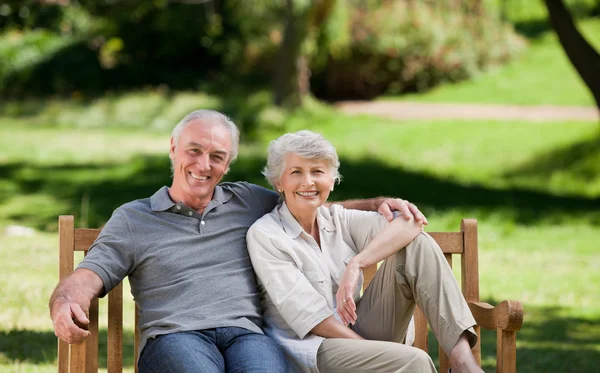 Старша пара сидить на лавці — стокове фото