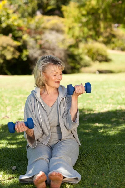 Retired woman doing her exercises in the park — Stock Photo, Image