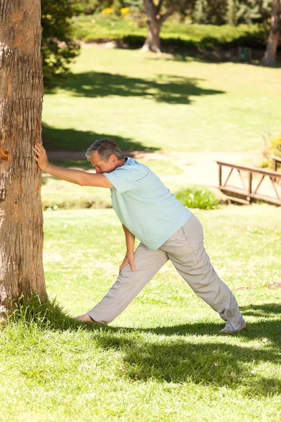 Mature man doing his streches in the park — Stock Photo, Image