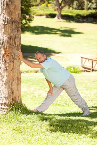 Homme mûr faisant ses streches dans le parc — Photo